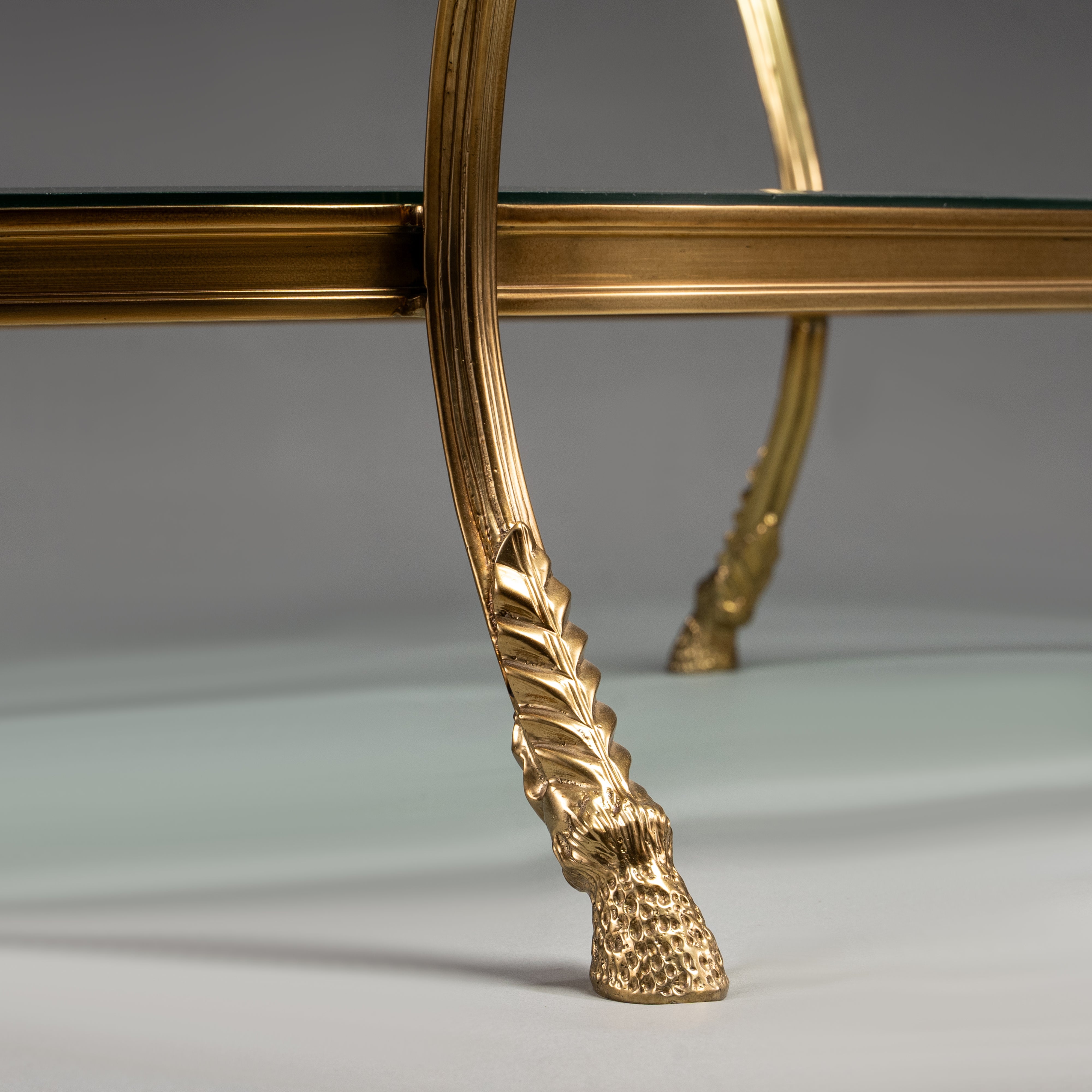 Oval Brass Coffee Table with Glass Shelves and Ram Head Accents