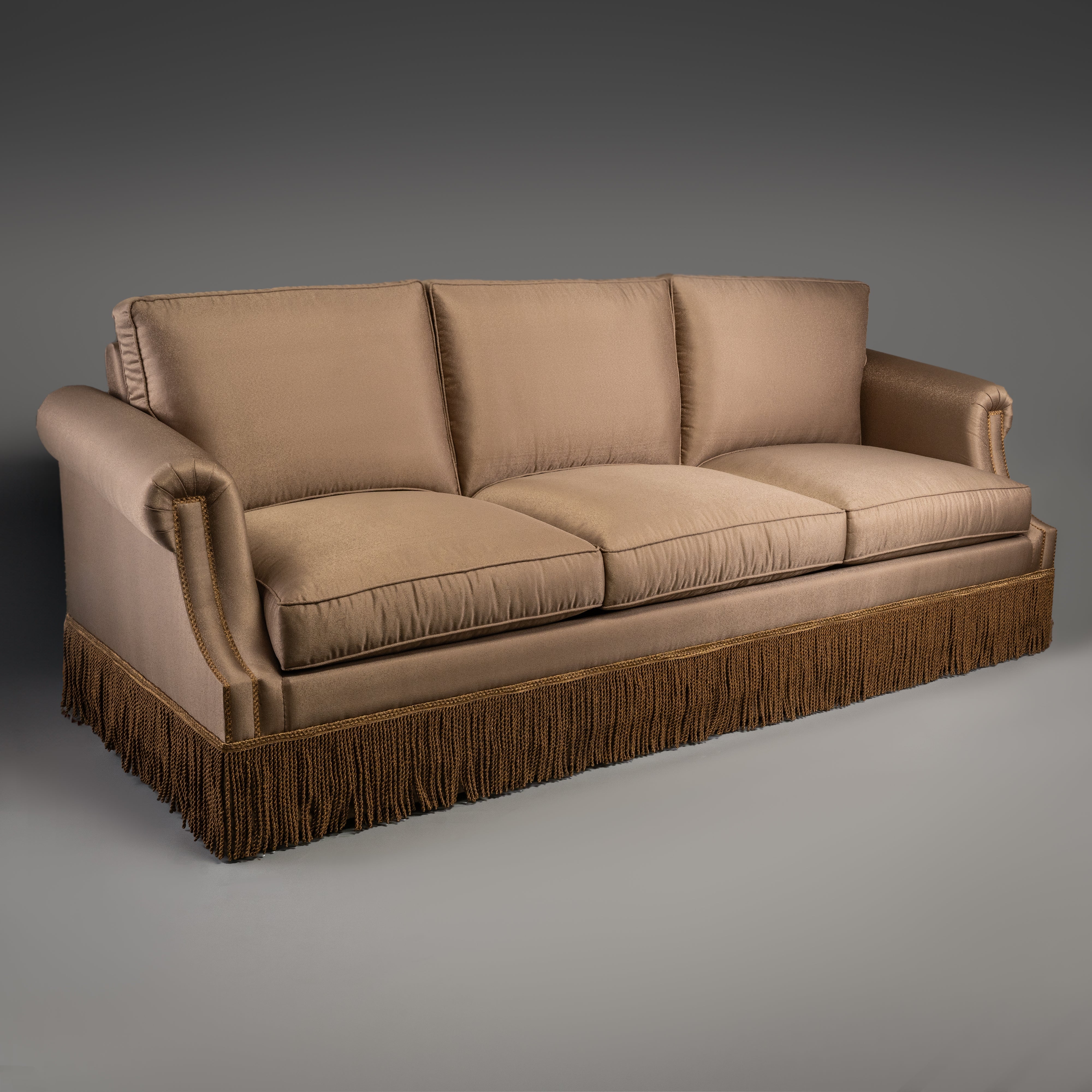 Classic Taupe Sofa with Rolled Arms and Decorative Fringe Skirt