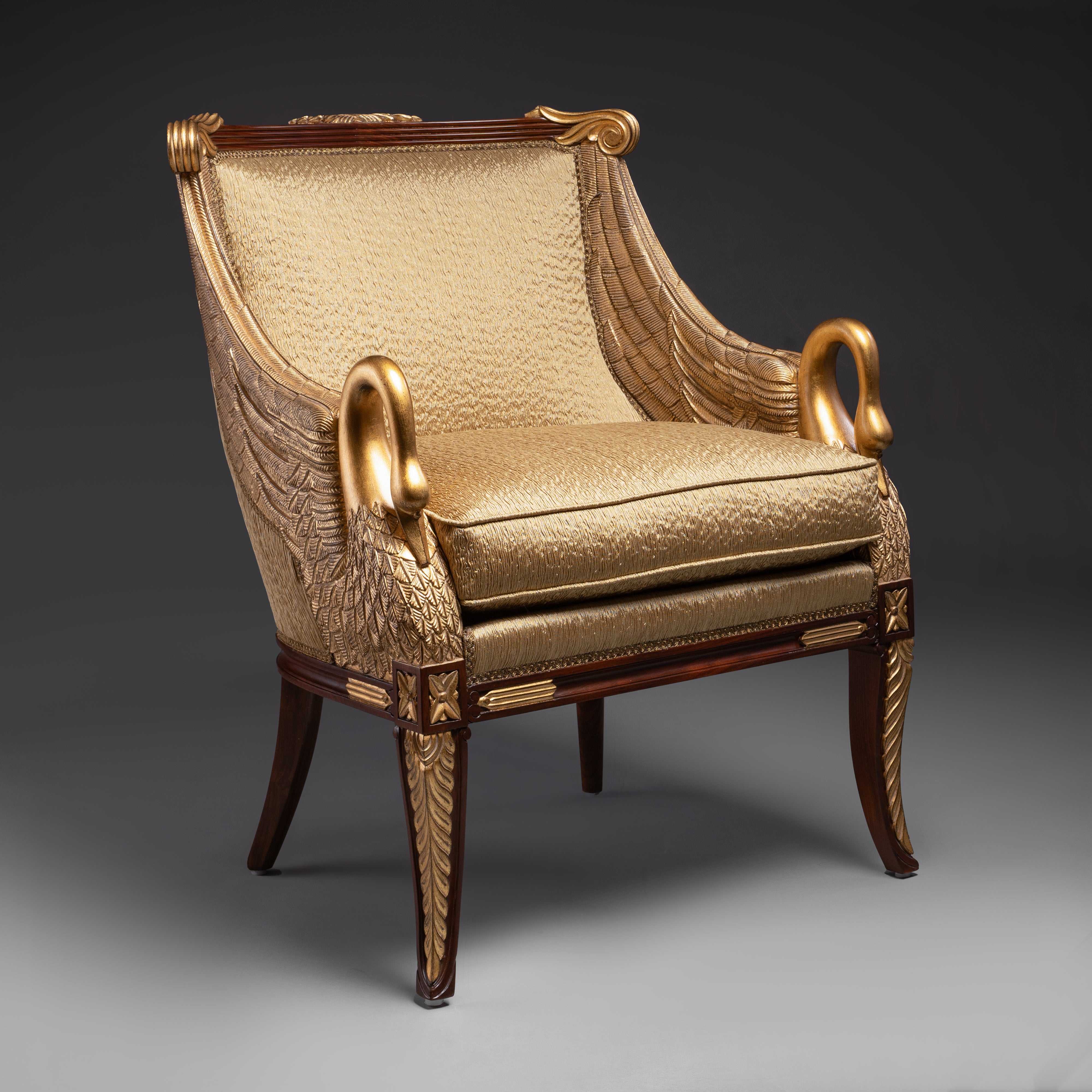 A regal Empire-style armchair featuring  exquisitely carved and gilded swan motifs,  embodying timeless elegance.