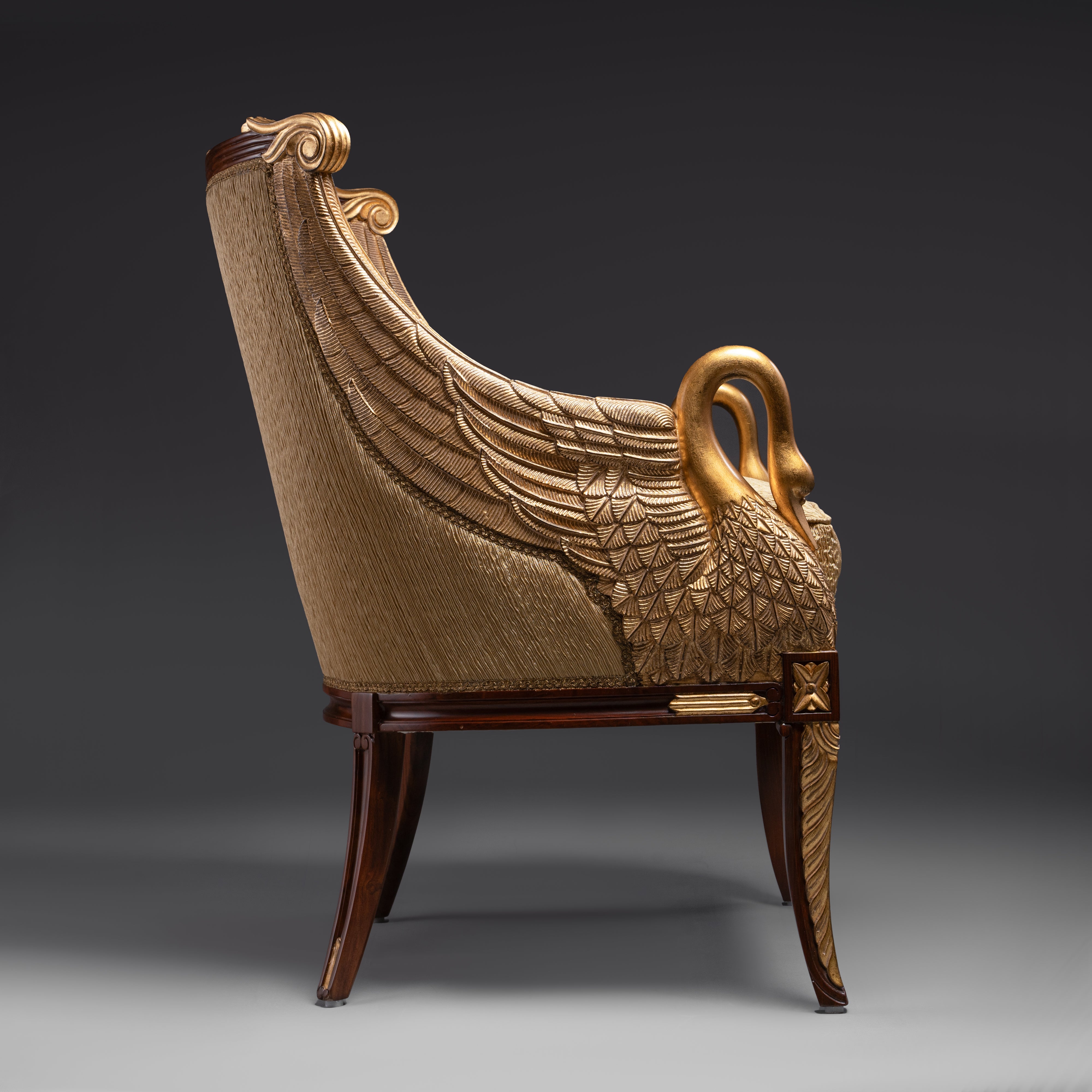 A regal Empire-style armchair featuring  exquisitely carved and gilded swan motifs,  embodying timeless elegance.