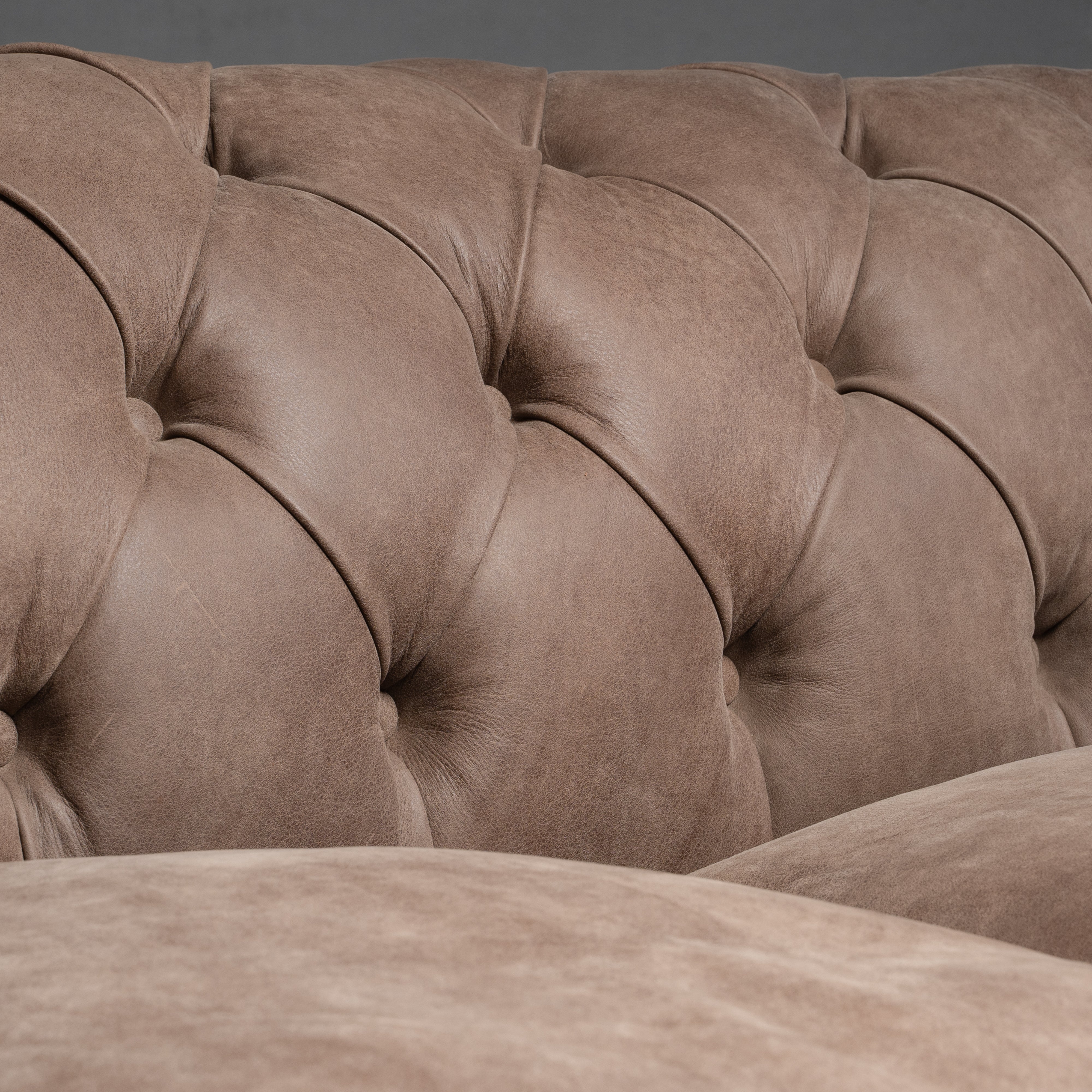 A timeless Chesterfield sofa with luxurious  tufted leather and elegantly rolled arms