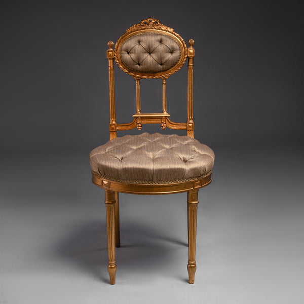 Opulent tufted chair with gilded accents and  regal charm.