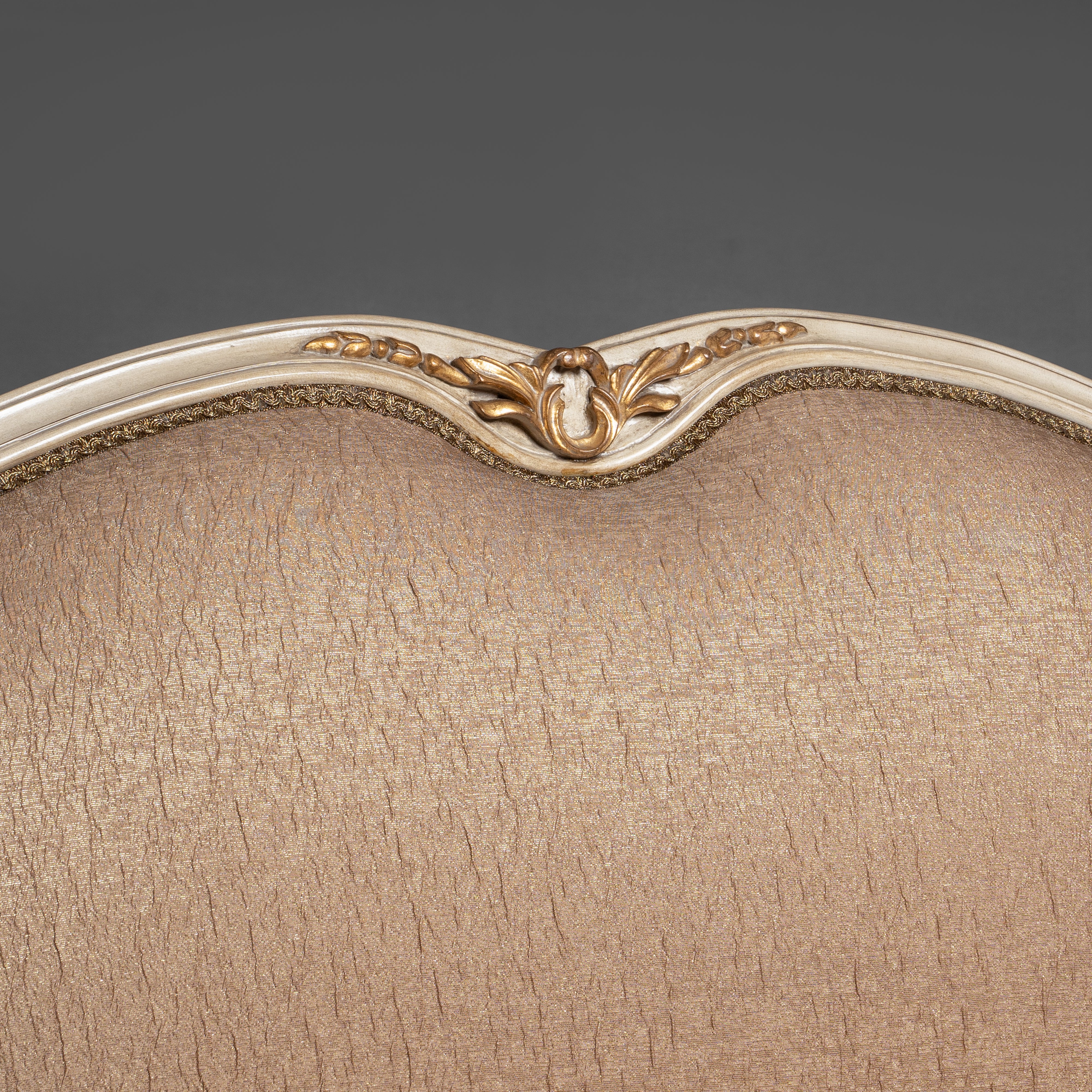 A regal Louis XV-style sofa with intricate  carvings and opulent upholstery.