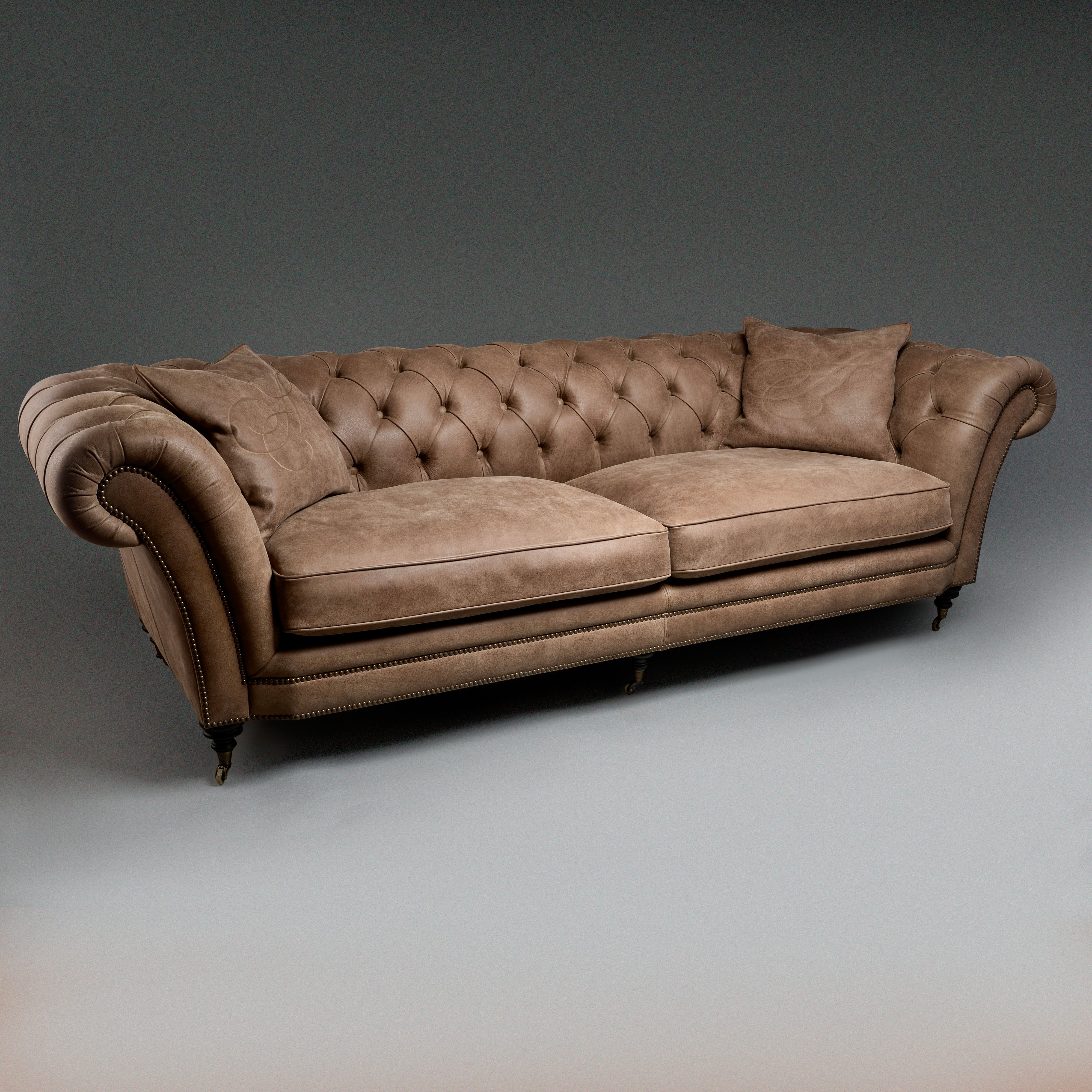 A timeless Chesterfield sofa with luxurious  tufted leather and elegantly rolled arms