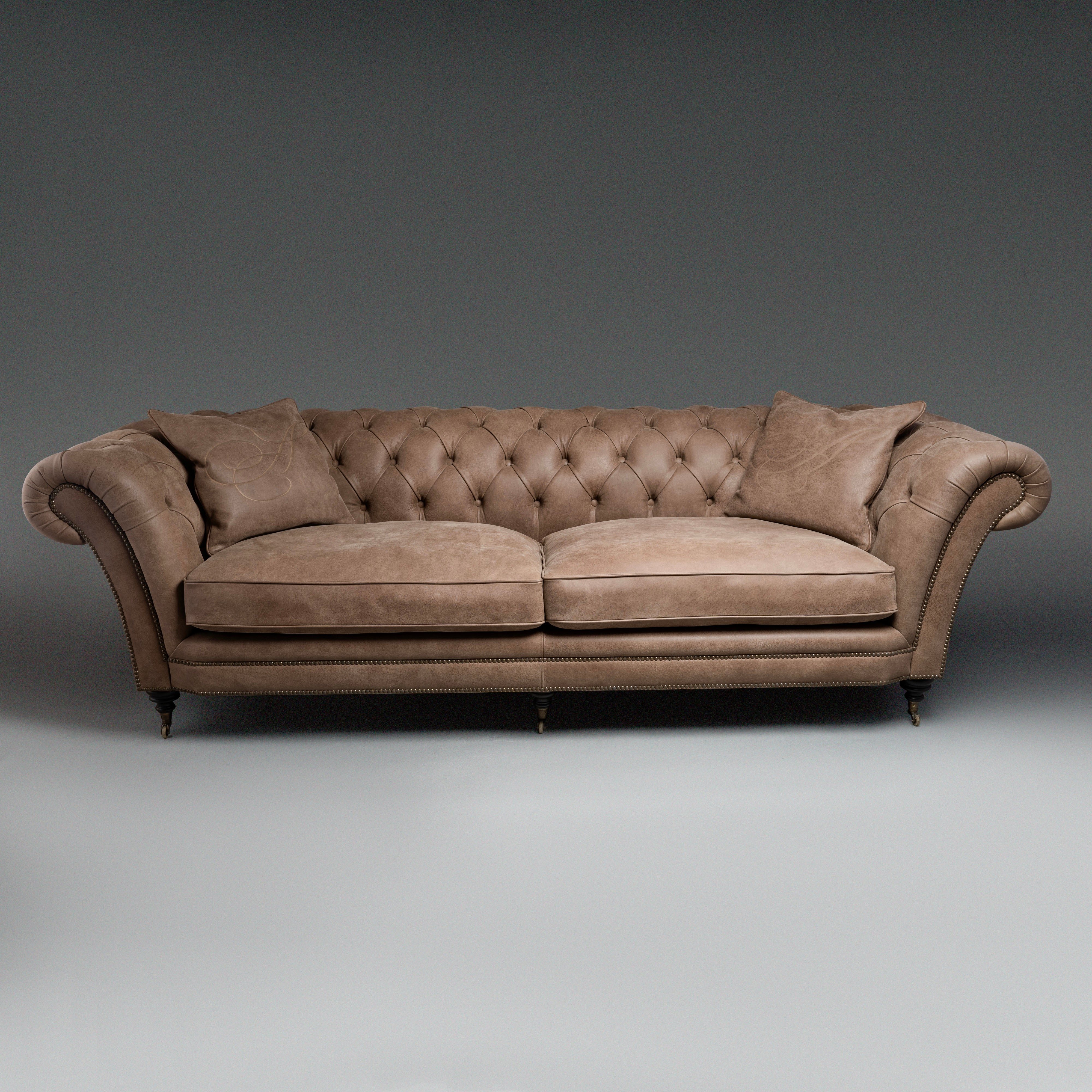 A timeless Chesterfield sofa with luxurious  tufted leather and elegantly rolled arms