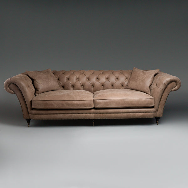 A timeless Chesterfield sofa with luxurious  tufted leather and elegantly rolled arms