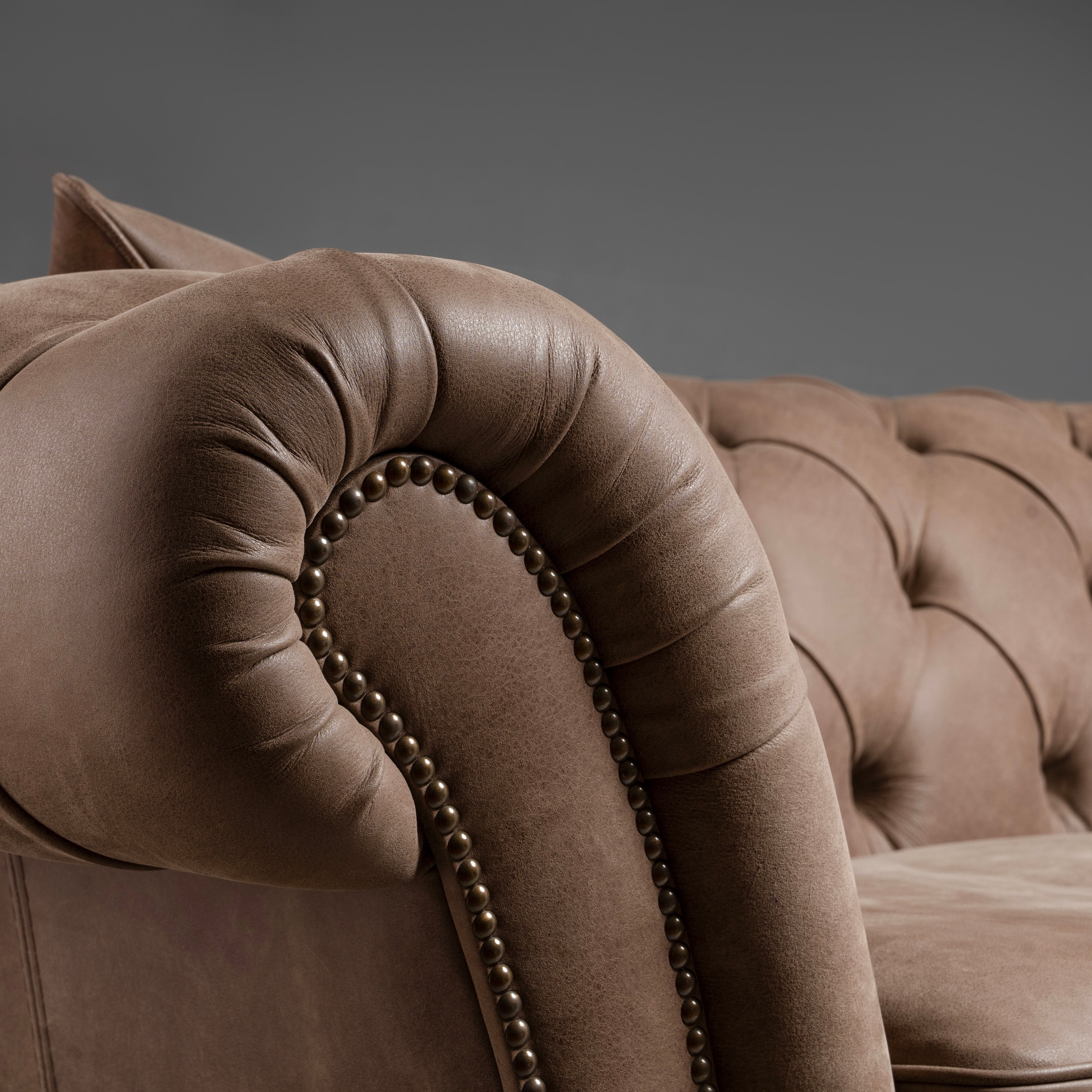 A timeless Chesterfield sofa with luxurious  tufted leather and elegantly rolled arms