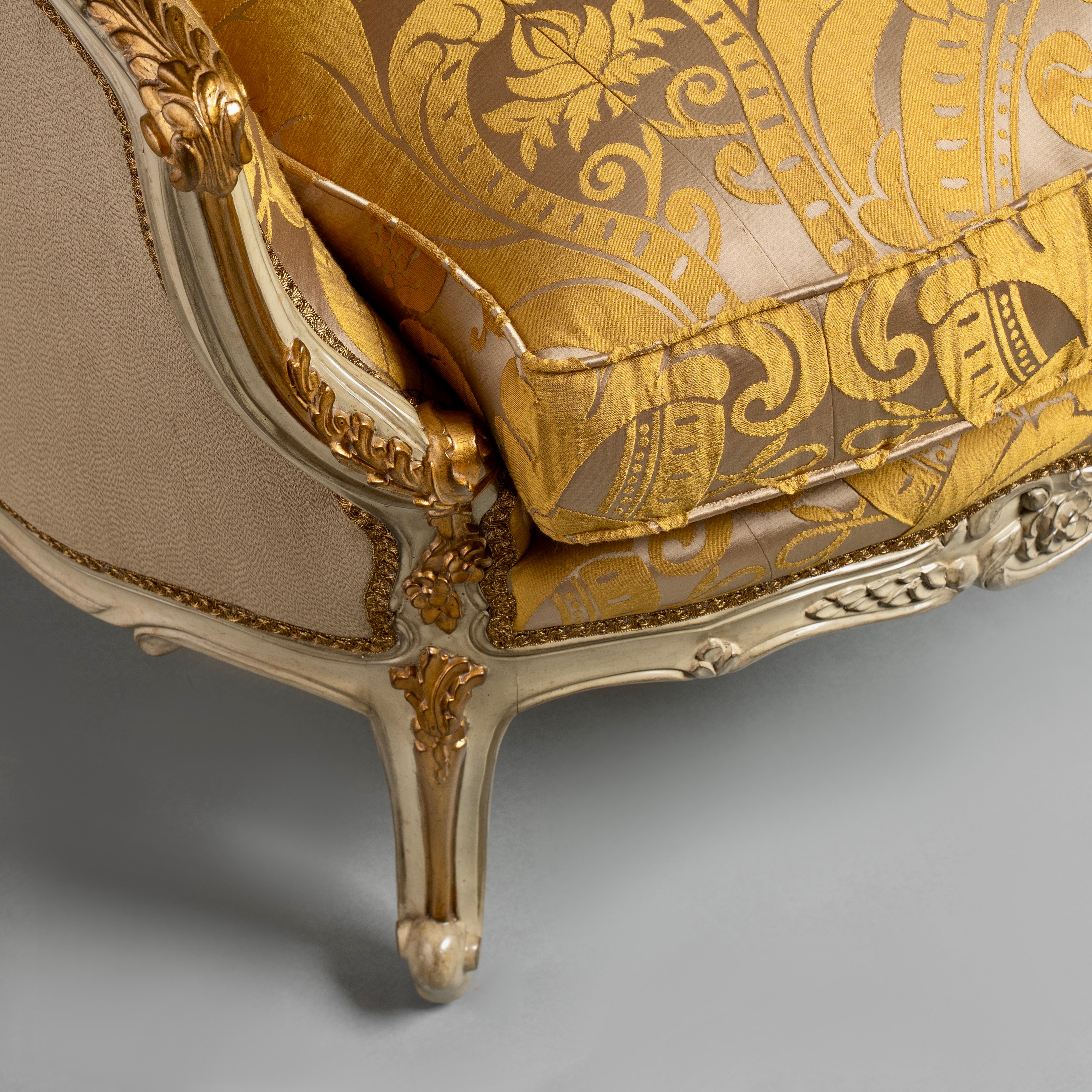 A luxurious Louis XV-style sofa with intricate  carvings and opulent gold damask  upholstery.