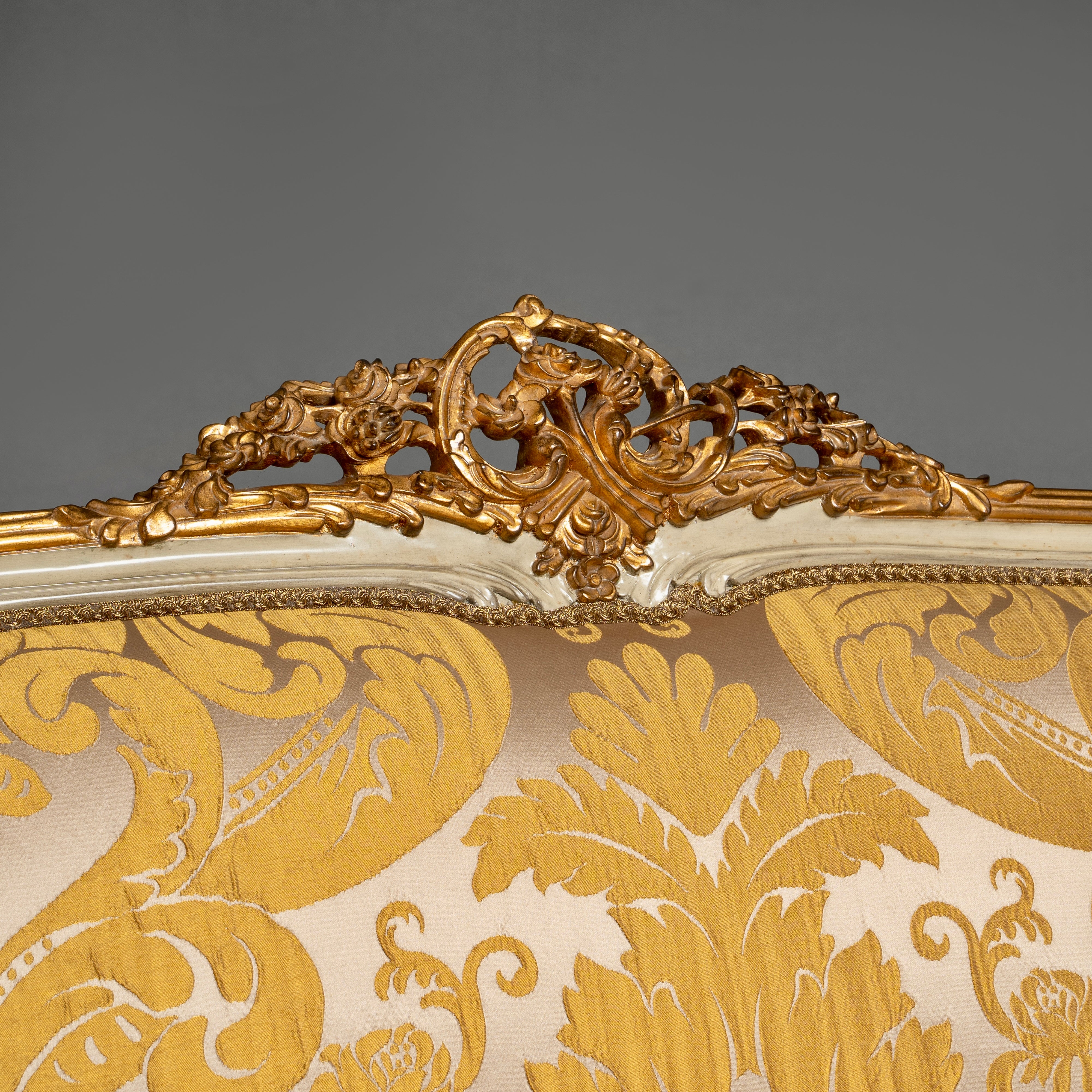 A luxurious Louis XV-style sofa with intricate  carvings and opulent gold damask  upholstery.